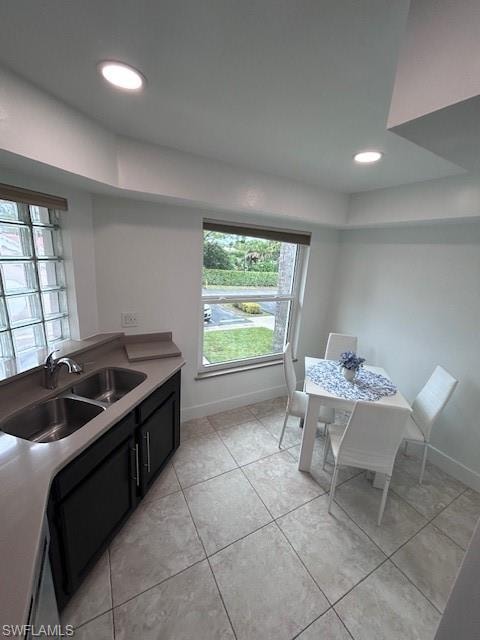 Kitchen with dark cabinets, recessed lighting, and light tile patterned floors