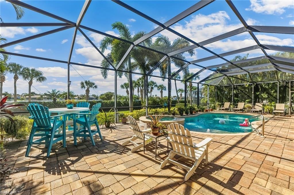 Pool & Spa with expansive paver deck spanning width of home. Areca palms on sides for privacy.
