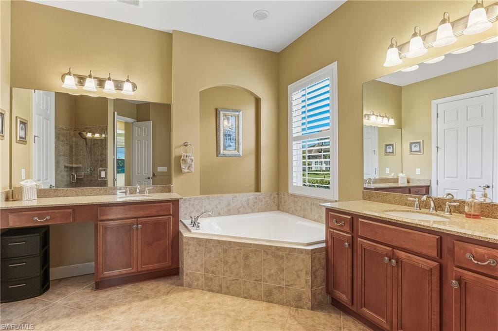 Main bathroom with dual sinks, tub and shower.