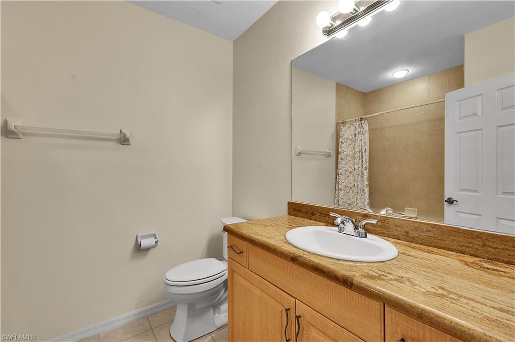 Full bathroom with light tile patterned flooring, vanity, and a shower with curtain