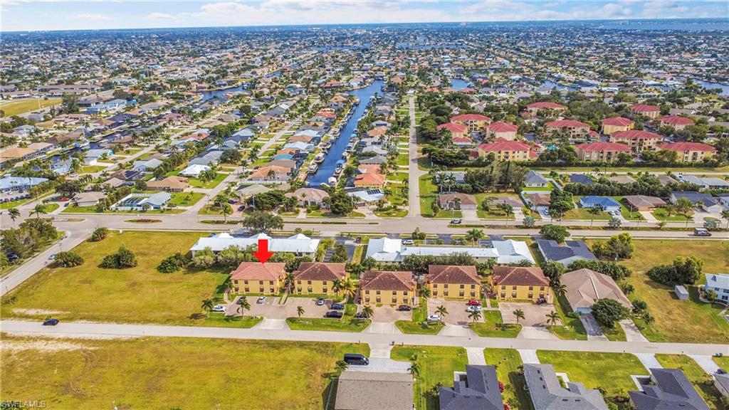 Aerial view of property and surrounding area with nearby suburban area