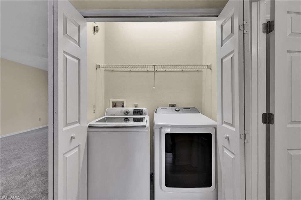 Laundry room featuring carpet and separate washer and dryer