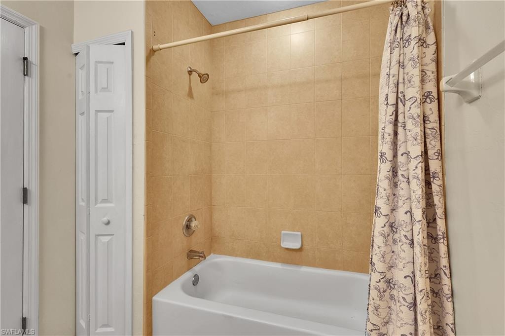 Bathroom with shower / bath combo and a closet