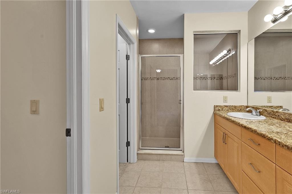 Full bathroom with vanity, light tile patterned flooring, a shower stall, and recessed lighting