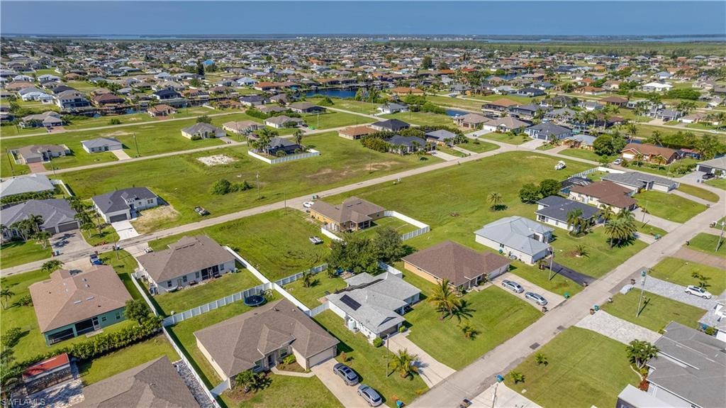 Aerial view of property's location featuring a nearby body of water and nearby suburban area