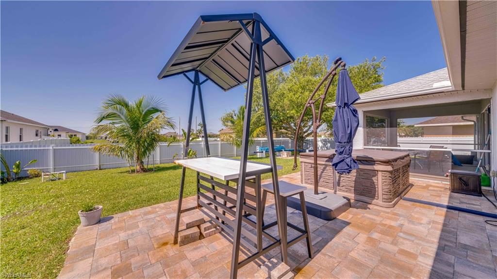 Fenced backyard with a patio and an outdoor kitchen