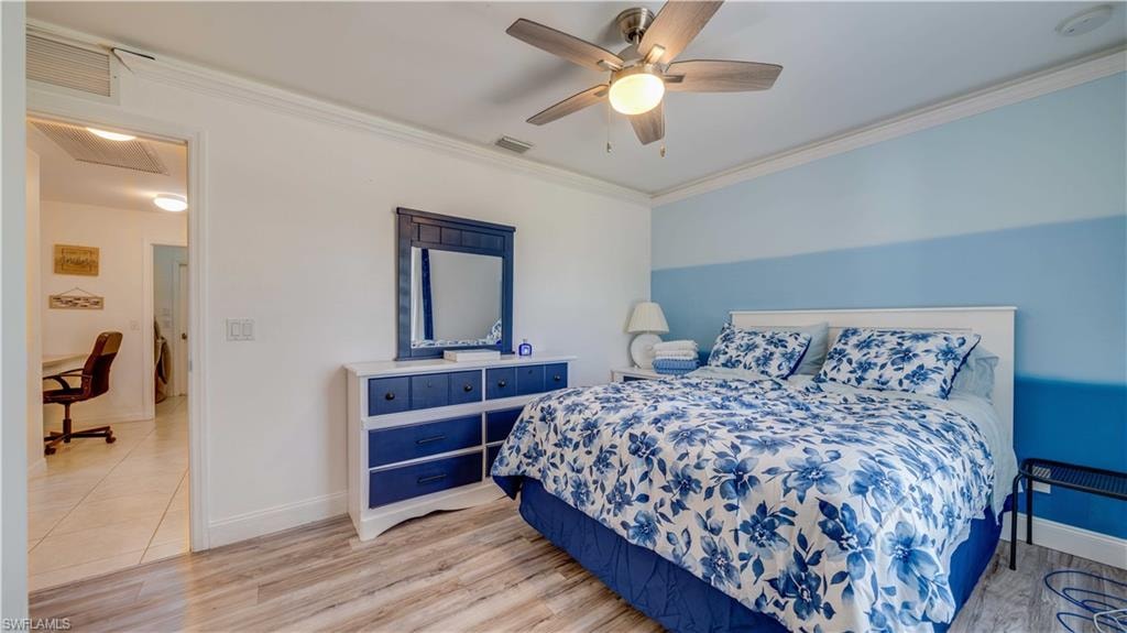 Bedroom featuring crown molding, light wood-type flooring, and ceiling fan