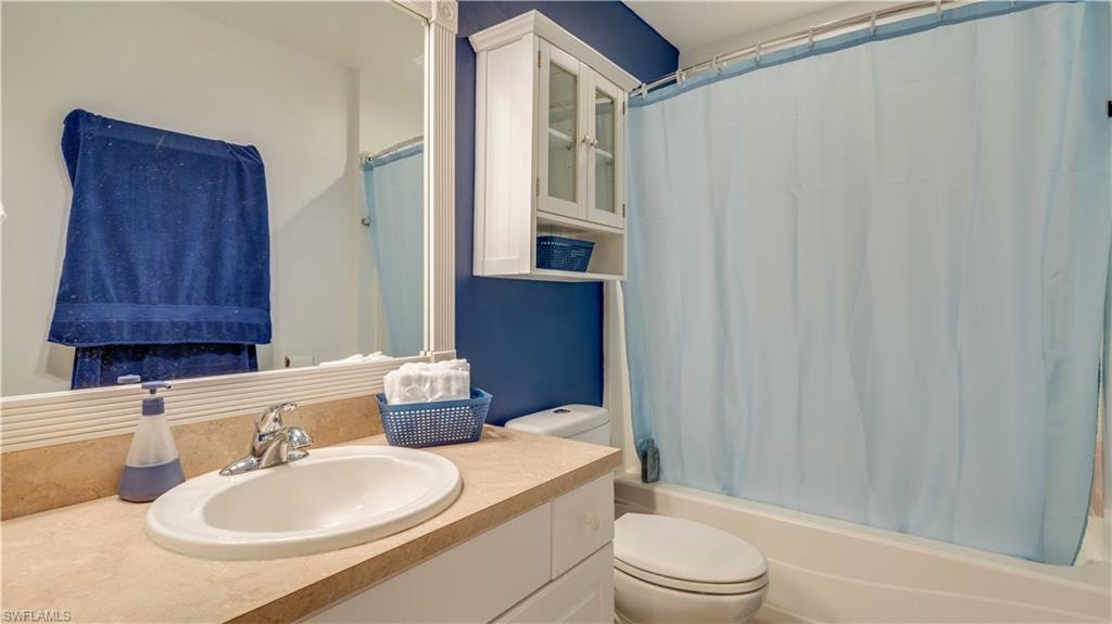 Bathroom with shower / bathtub combination with curtain and vanity