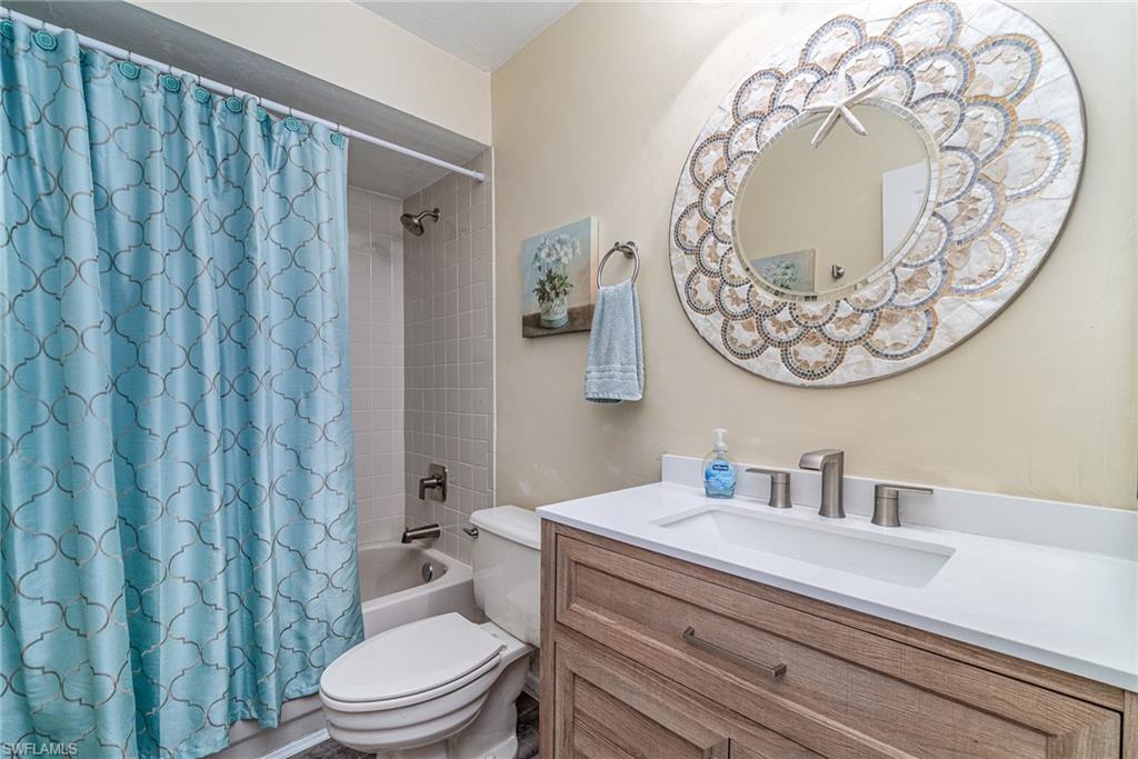 Bathroom with shower / bath combo with shower curtain and vanity