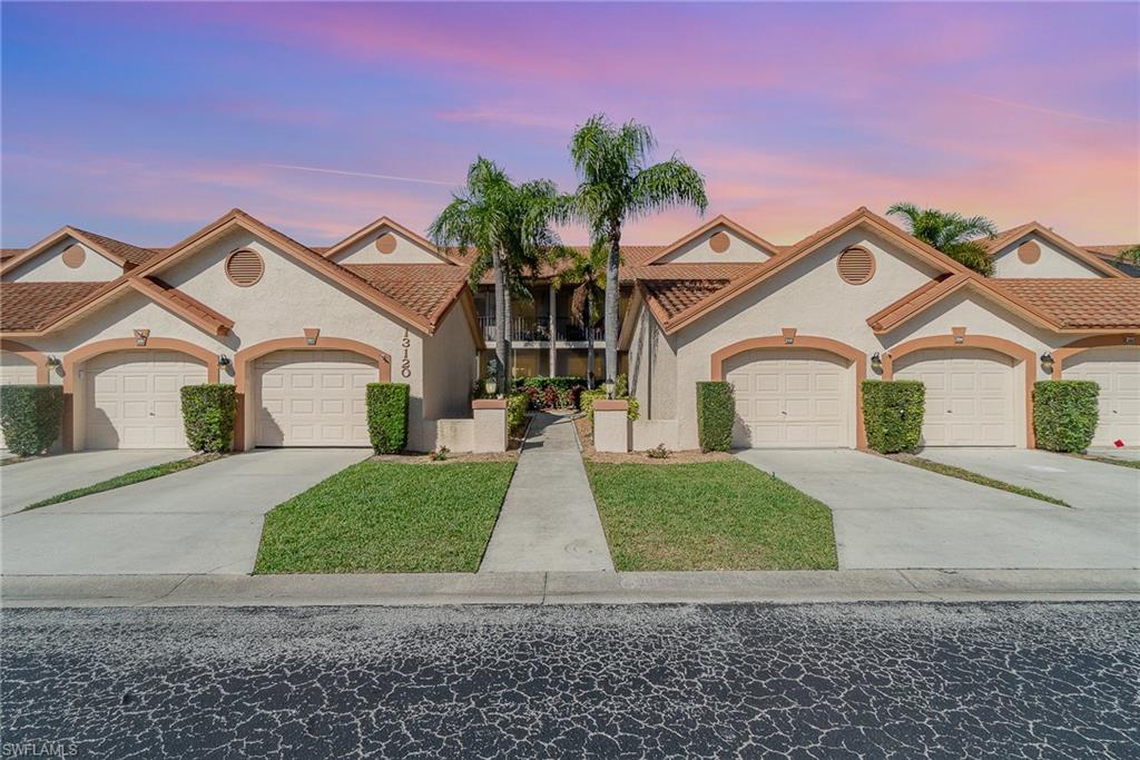 Mediterranean / spanish-style house with a tiled roof, stucco siding, a front lawn, and concrete driveway