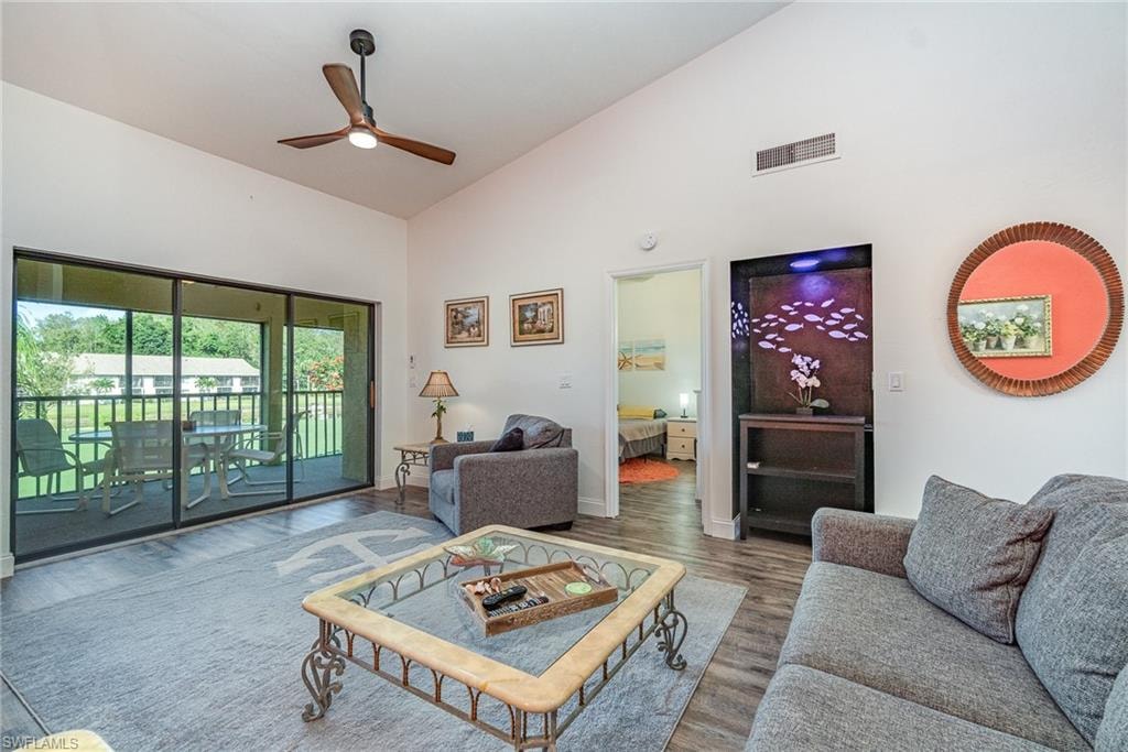 Living area featuring high vaulted ceiling, a ceiling fan, and wood finished floors