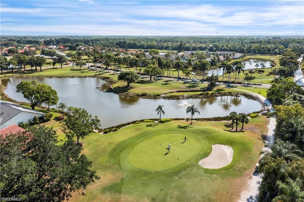 Aerial perspective of suburban area with a golf club and a nearby body of water