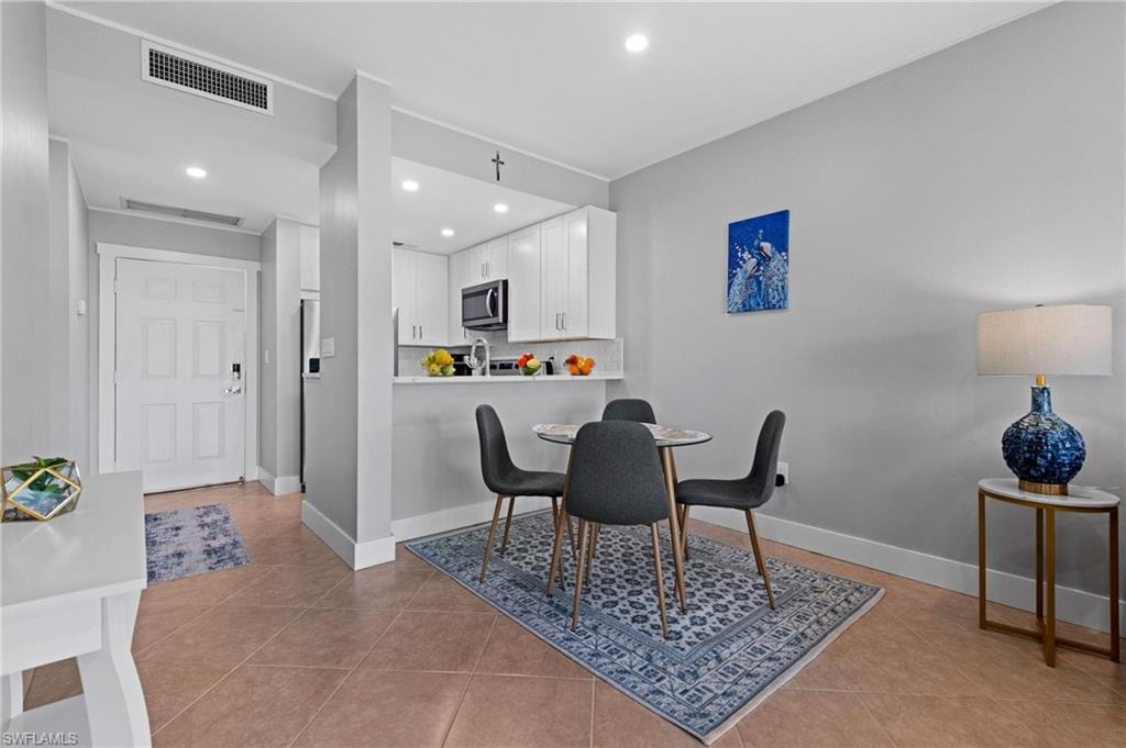 Dining area with light tile patterned flooring and recessed lighting