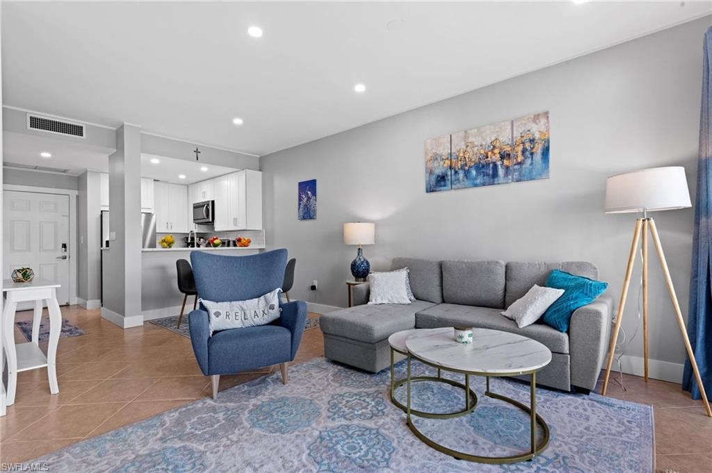 Living area featuring light tile patterned floors and recessed lighting