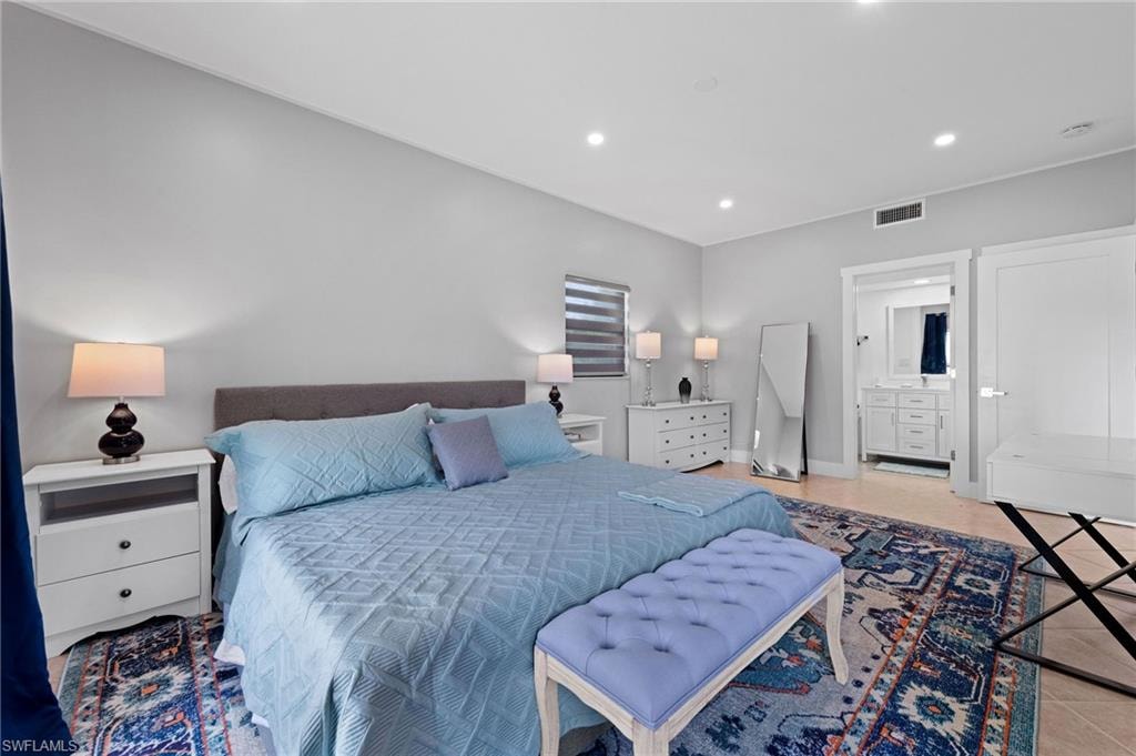 Bedroom featuring recessed lighting, light tile patterned flooring, and ensuite bath