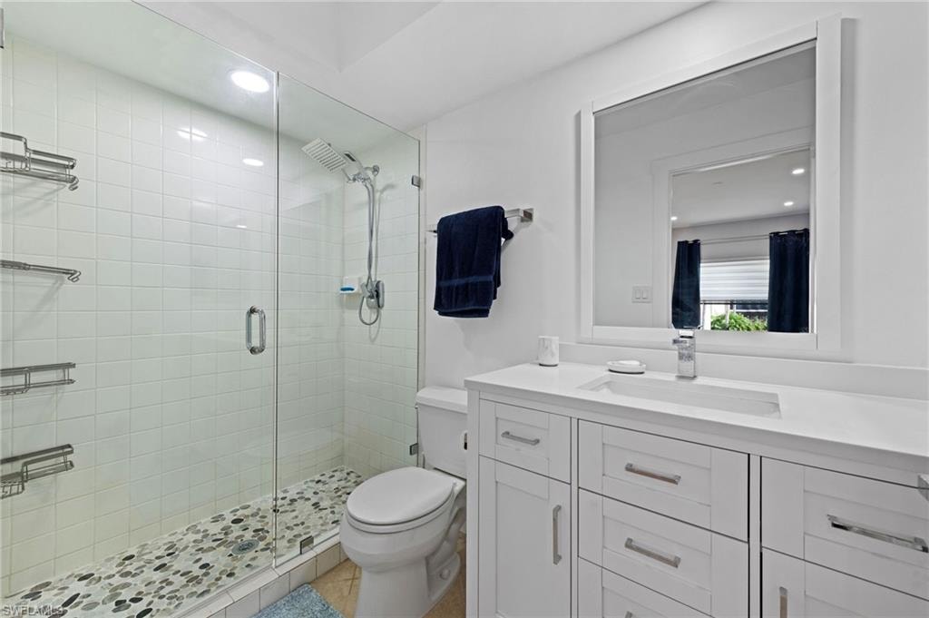 Full bath featuring recessed lighting, vanity, a stall shower, and light tile patterned floors