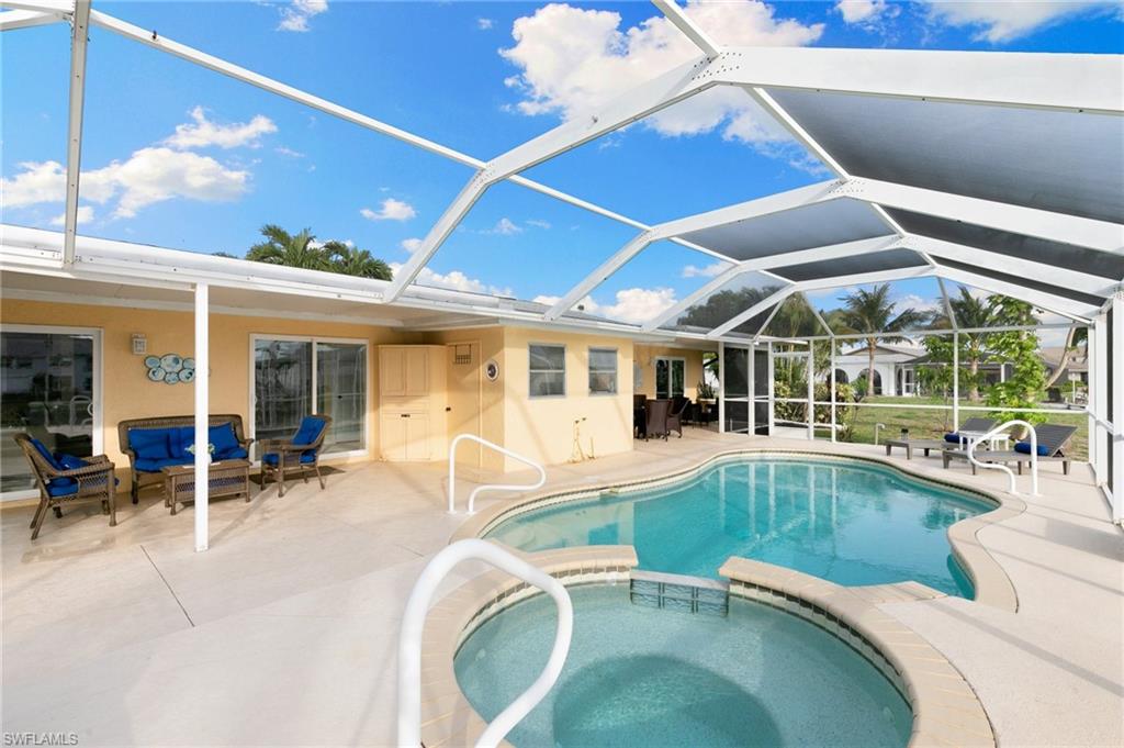 View of pool with a sunroom, a patio, a pool with connected hot tub, a lanai, and outdoor lounge area