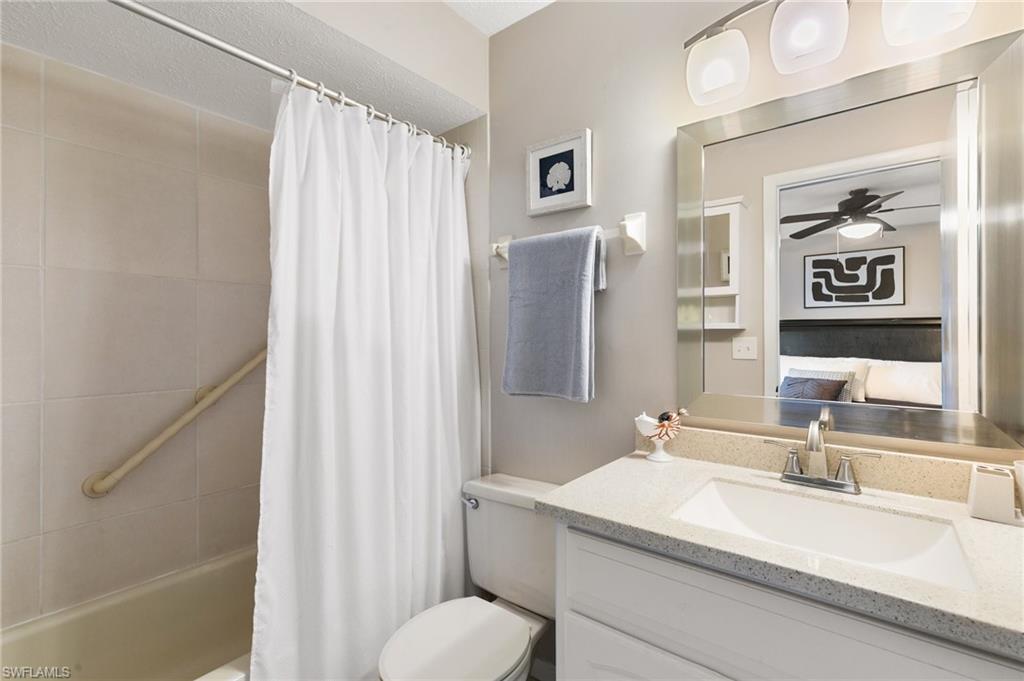Bathroom with vanity, ensuite bath, shower / bath combo with shower curtain, and a ceiling fan