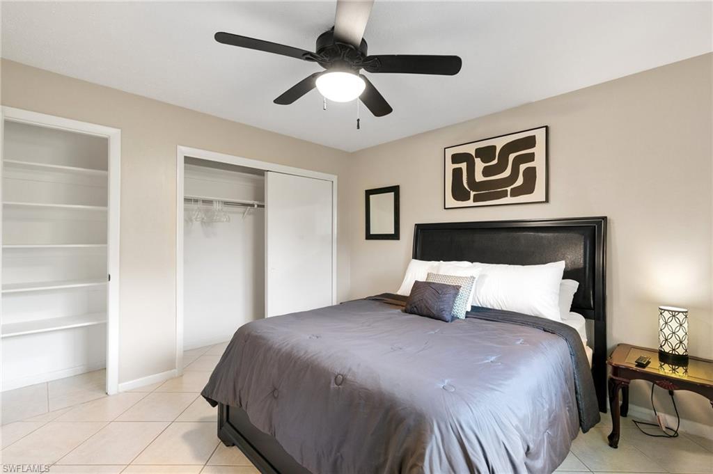 Bedroom featuring two closets, light tile patterned flooring, and ceiling fan