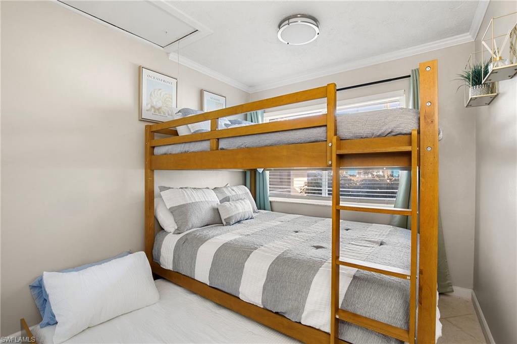 Bedroom with attic access and ornamental molding