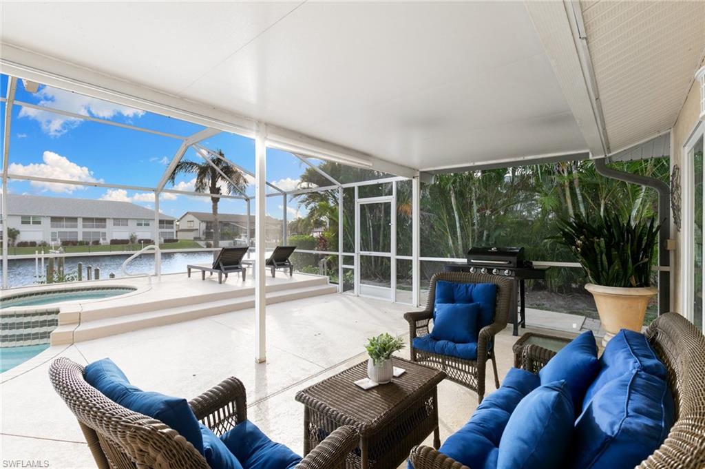 Sunroom / solarium featuring a hot tub, a patio area, a water view, an outdoor hangout area, and plenty of natural light