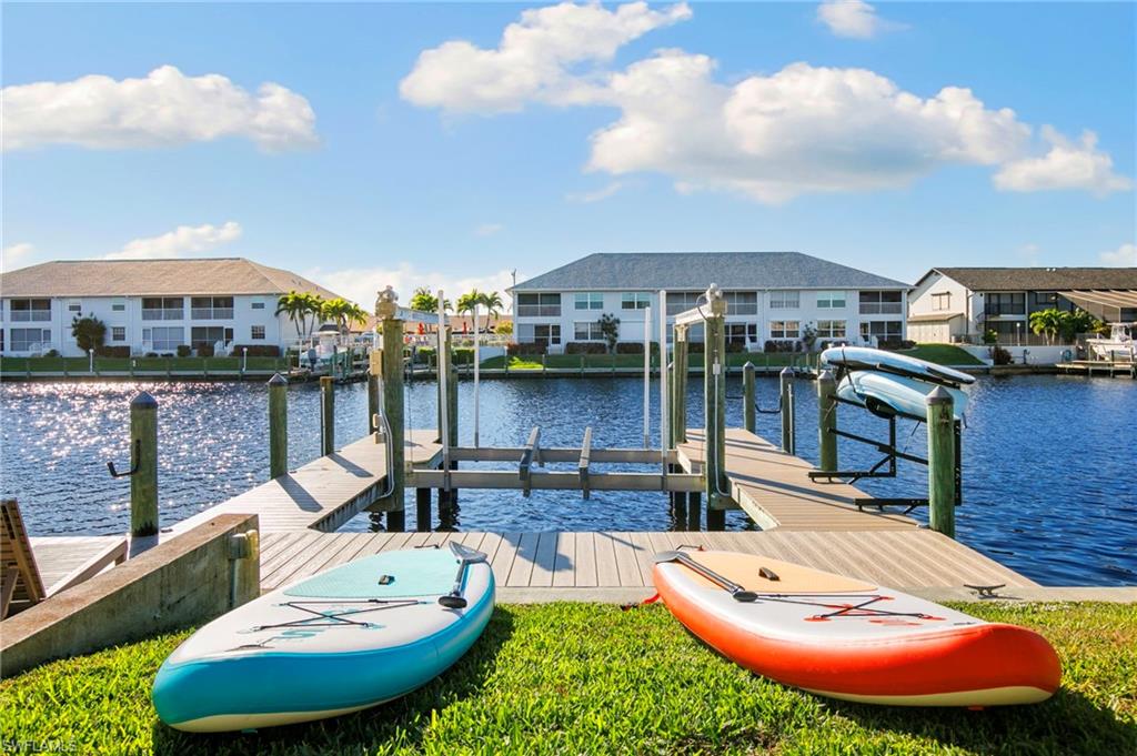Dock with a water view, a residential view, and boat lift