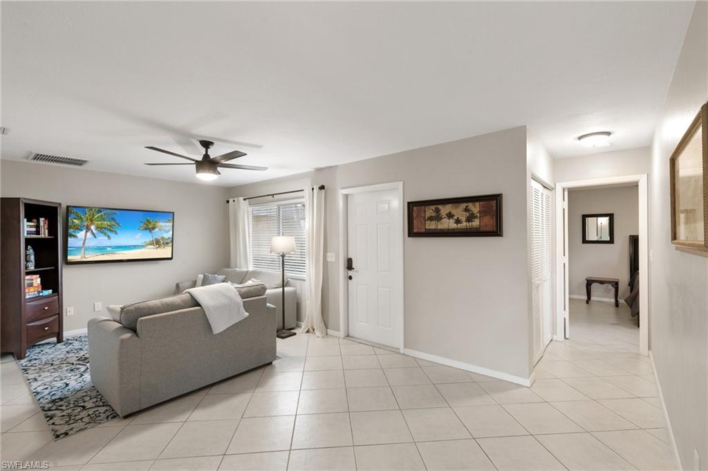 Living room with light tile patterned flooring and a ceiling fan
