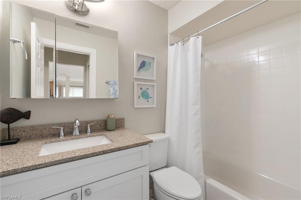 Full bath with shower / tub combo with curtain and vanity