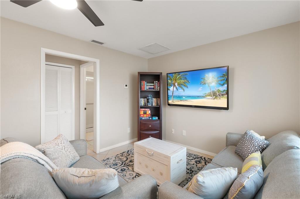 Tiled living area with baseboards and a ceiling fan