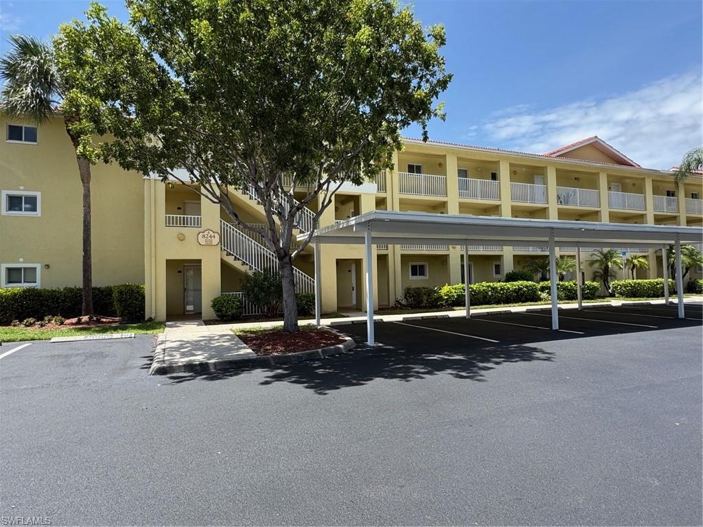 View of building exterior with covered parking and stairs
