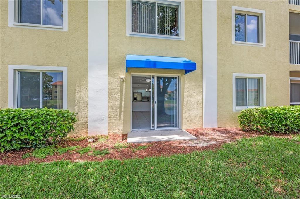 Entrance to property with stucco siding and a lawn