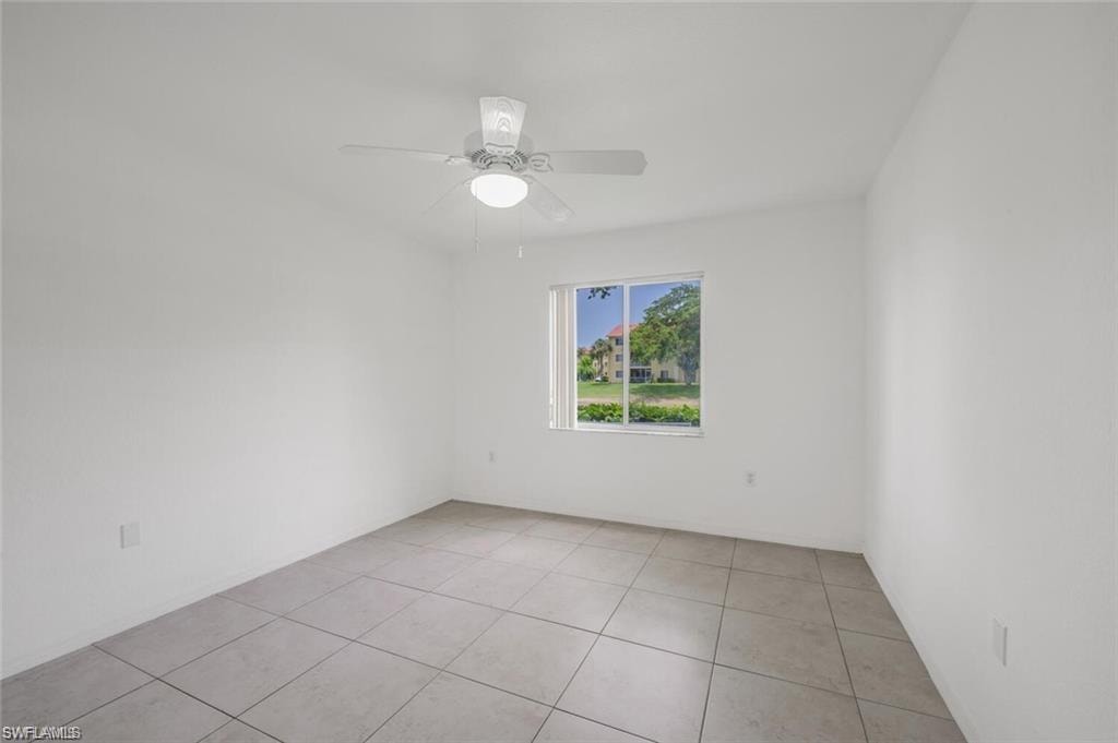 Unfurnished room featuring light tile patterned floors and a ceiling fan