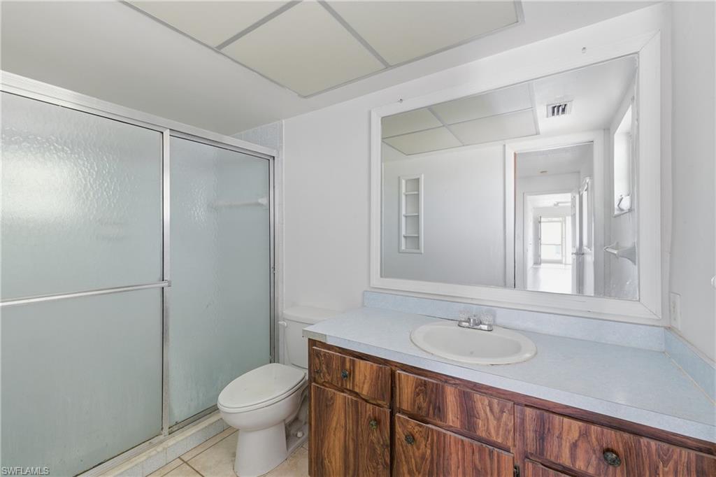 Bathroom with vanity, a shower stall, and light tile patterned floors