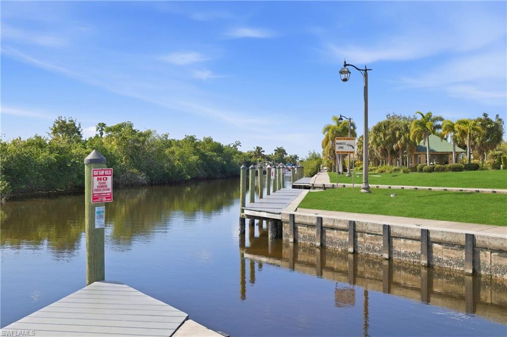 Dock area with a lawn and a water view