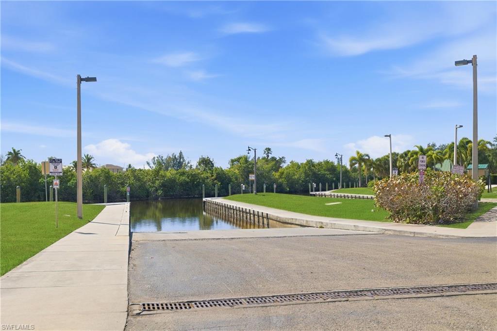 View of home's community featuring a boat ramp, a water view, and view of wooded area