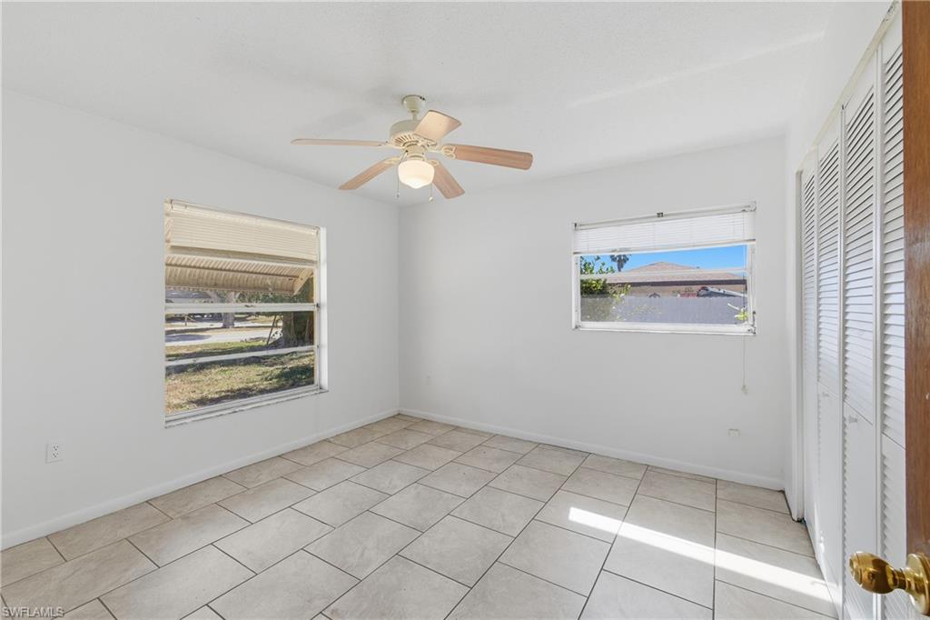 Unfurnished bedroom featuring a closet, ceiling fan, and light tile patterned floors