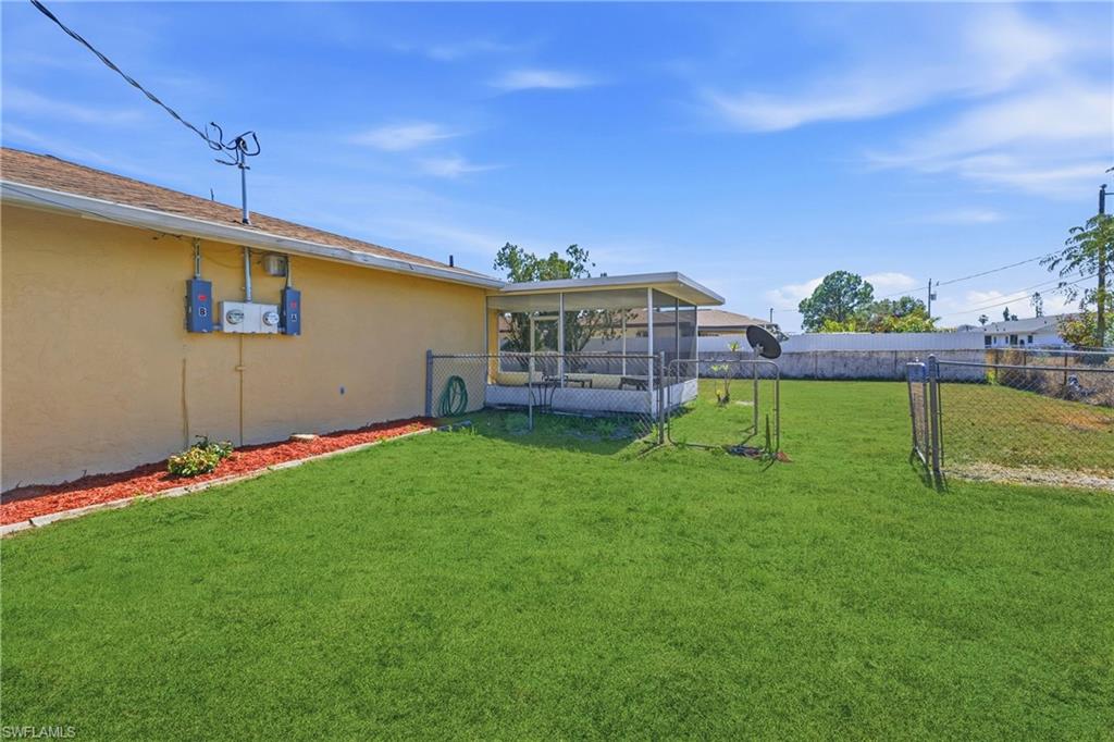 Fenced backyard featuring a sunroom