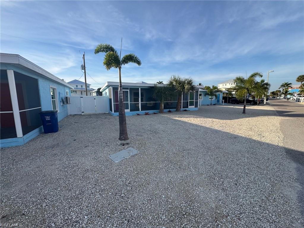 View of yard featuring a sunroom and a gate