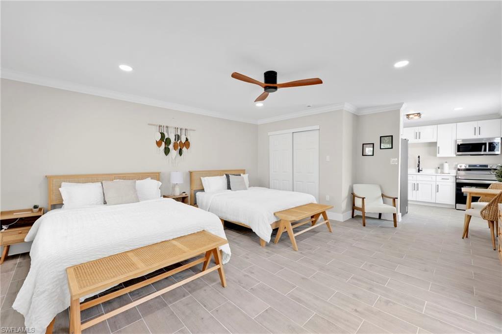 Bedroom featuring crown molding, a closet, recessed lighting, ceiling fan, and wood tiled floors