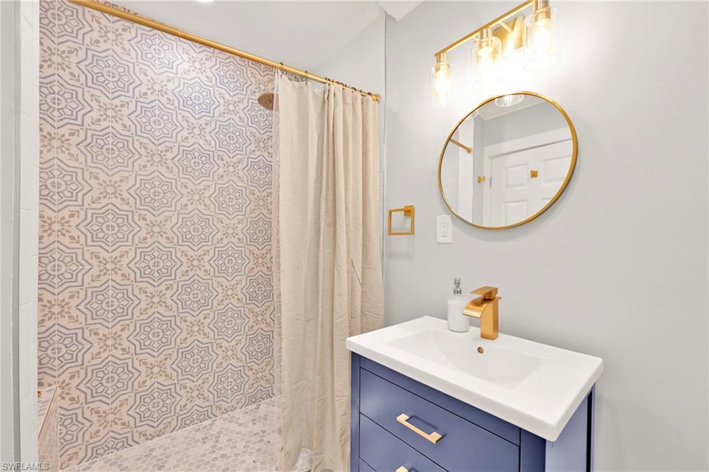 Full bathroom with vanity and a shower stall
