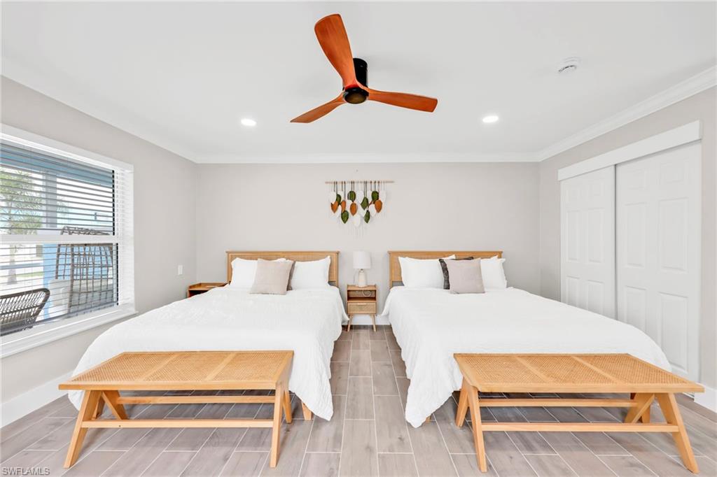 Bedroom with wood finish floors, ceiling fan, ornamental molding, recessed lighting, and a closet