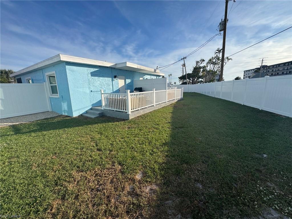 Back of house featuring a fenced backyard, a wooden deck, and stucco siding