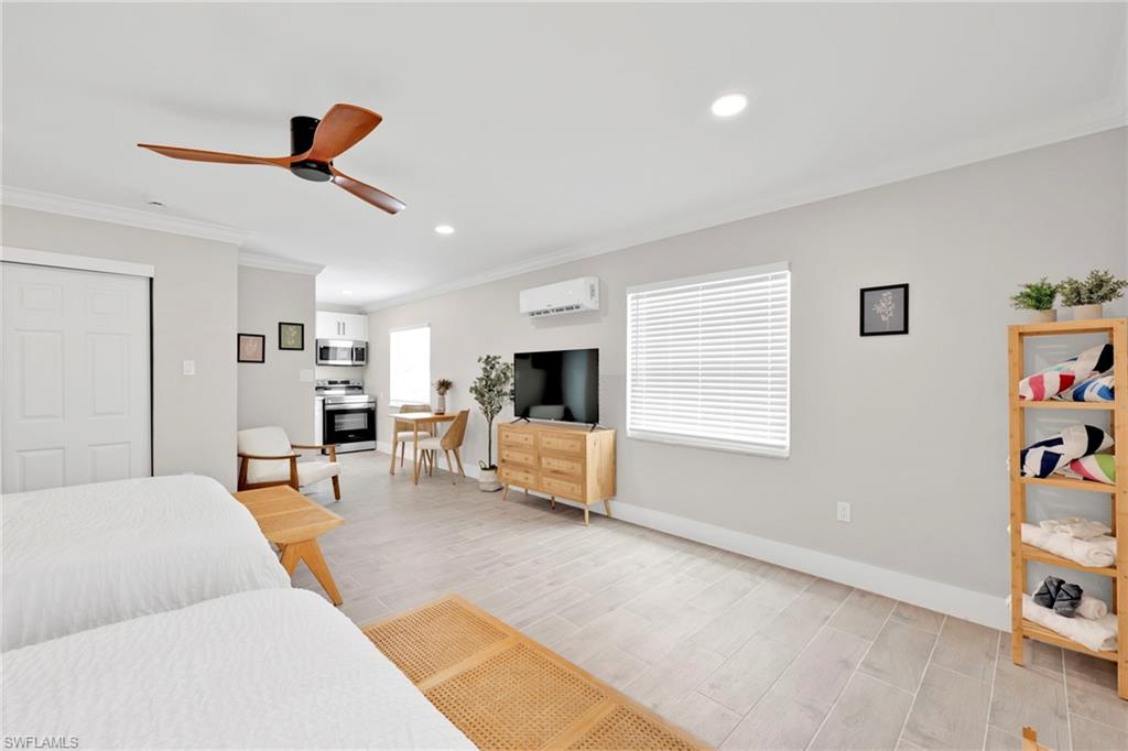 Bedroom with wood finish floors, a closet, ornamental molding, ceiling fan, and recessed lighting