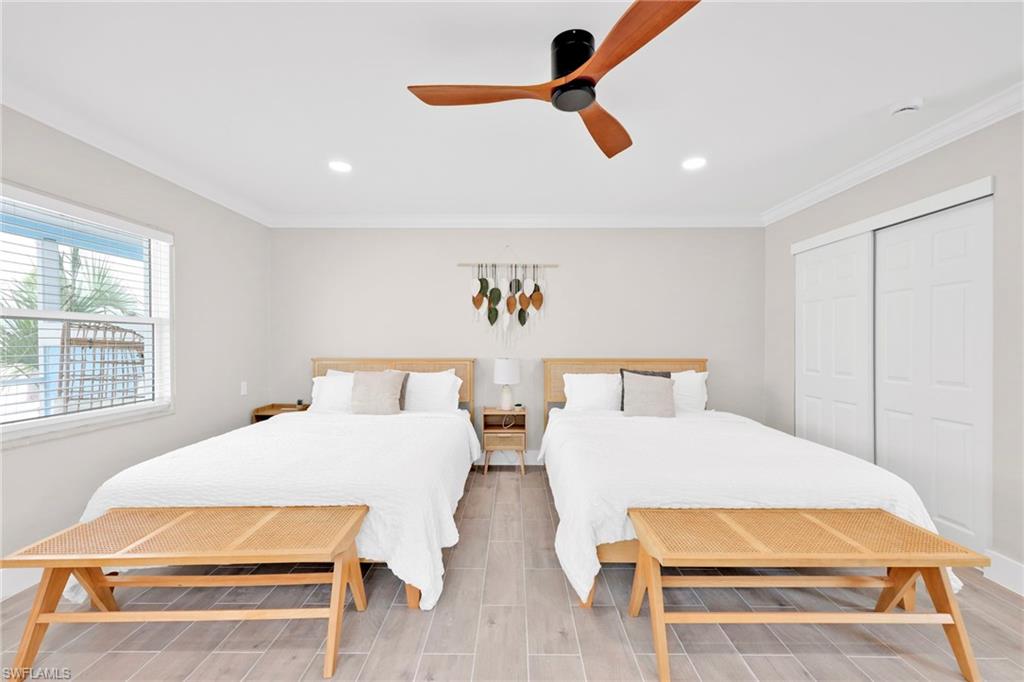 Bedroom featuring ornamental molding, a ceiling fan, wood tiled floors, recessed lighting, and a closet