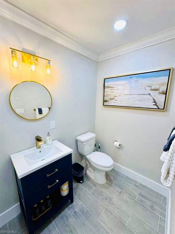 Bathroom with crown molding, vanity, and recessed lighting