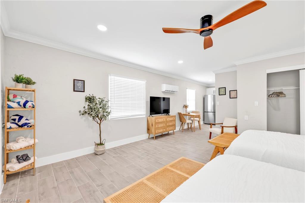 Bedroom featuring freestanding refrigerator, ornamental molding, a ceiling fan, a closet, and recessed lighting
