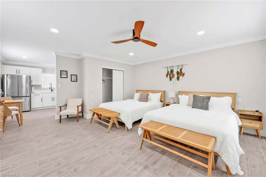 Bedroom featuring freestanding refrigerator, a closet, recessed lighting, ornamental molding, and ceiling fan
