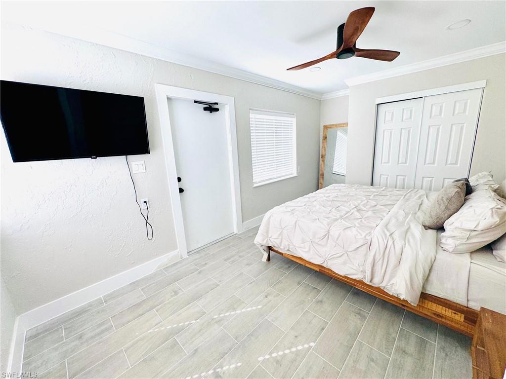 Bedroom featuring ornamental molding, a closet, wood finish floors, and ceiling fan