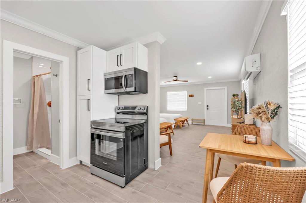 Kitchen featuring appliances with stainless steel finishes, crown molding, recessed lighting, white cabinets, and ceiling fan