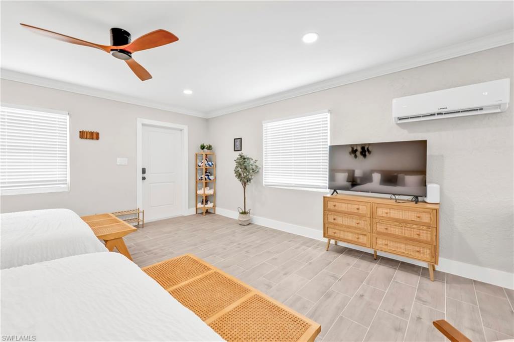 Bedroom featuring ornamental molding, an AC wall unit, a ceiling fan, recessed lighting, and wood finish floors